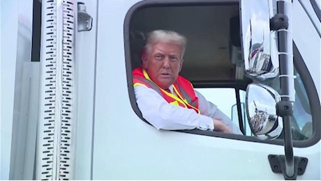 Usa 2024, Trump su un camion della spazzatura con un giubbotto da netturbino. Ai suoi elettori: Siete il cuore e l'anima dell'America