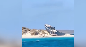 Uno yacht di lusso si arena su una spiaggia, turisti increduli