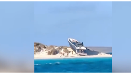 Uno yacht di lusso si arena su una spiaggia, turisti increduli