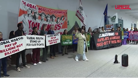 VIDEO Cop29, i manifestanti protestano con un grosso serpente infuocato per chiedere un accordo sui finanziamenti per il clima