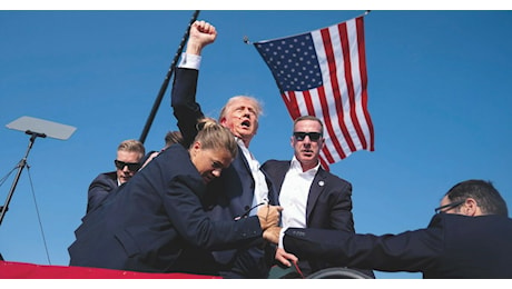 Trump, l’Immortalato. Sangue, pugno e bandiera: la foto che è già il suo altare