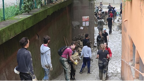 In via Andrea Costa arrivano gli angeli del fango: “Non si può stare con le mani in mano”